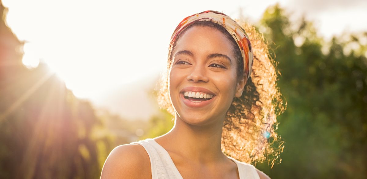 happy woman enjoying sunshine with clear aligners