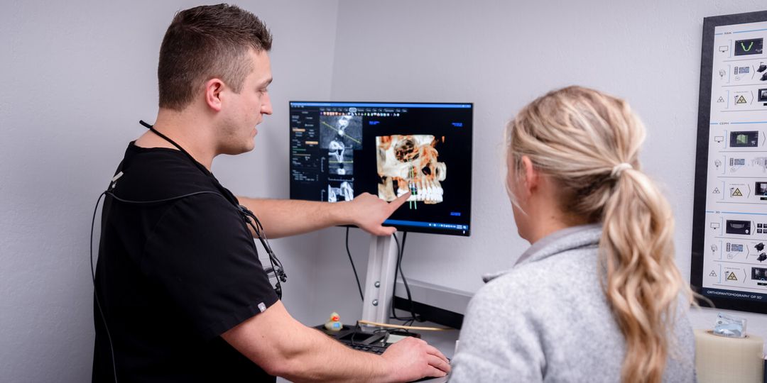 Dentist in Grants Pass, OR explaining digital dental X-ray results to patient during consultation