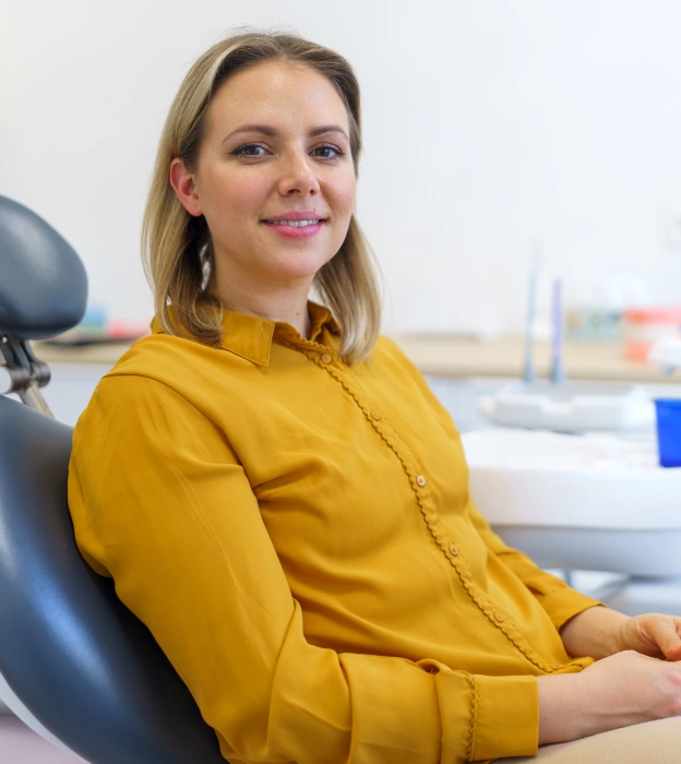 Woman in yellow top sitting in a dental chair