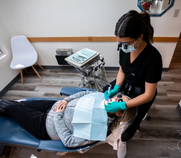 A patient lying in a dental chair and receiving dental treatment